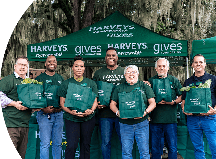 Group photo of Harveys Gives volunteers with bags of donated turkeys