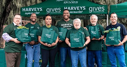 Group photo of Harveys Gives volunteers with bags of donated turkeys