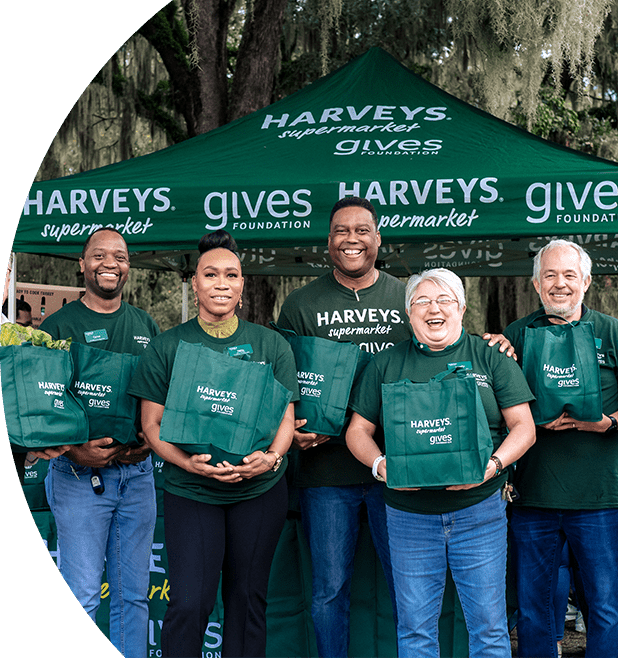 Group photo of Harveys Gives volunteers with bags of donated turkeys