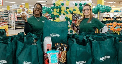 Harveys Supermarket employees smiling with bags of groceries