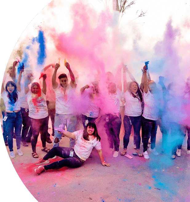 Group of people cheering and throwing colored powder in the air.