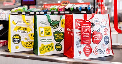 SE Grocers community bags on a conveyor belt.