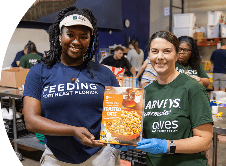 Gives Foundation volunteers holding an SE Grocers Toasted Oats product.