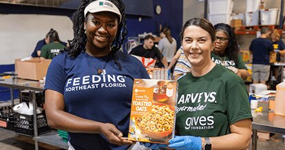 Gives Foundation volunteers holding an SE Grocers Toasted Oats product.