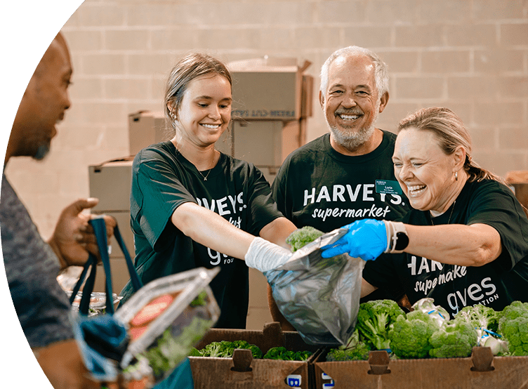 Gives Foundation volunteers joyfully arranging produce for donations.