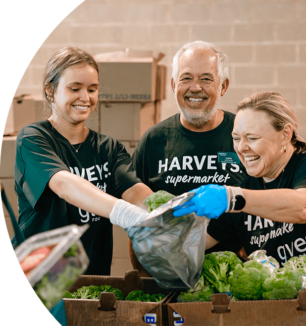 Gives Foundation volunteers joyfully arranging produce for donations.