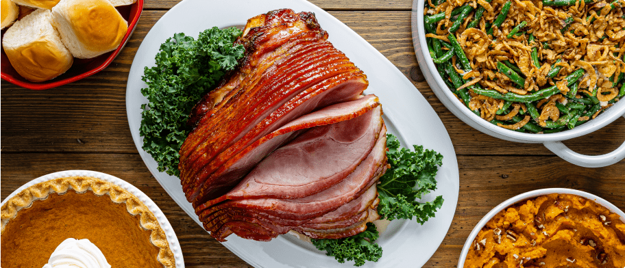 Delicious Holiday dinner with a ham on a platter in the center.