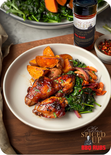 Brown Sugar Bourbon Style BBQ Chicken Thighs, Spicy Sweet Potato Fries & Sautéed Kale served on a plate.