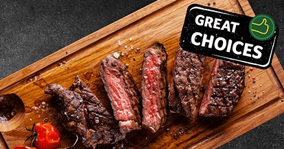 Cooked meat cut into pieces placed on a wooden board. 