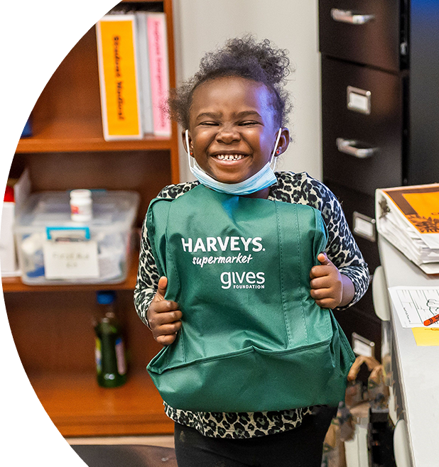 Girl happily holding a Haveys Supermaket gives foundation bag
