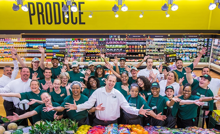 Group of Harveys Supermarket associates cheering and smiling